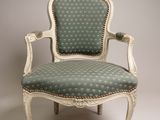 an old chair with a green and white upholstered upholstered seat