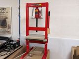 une chaise rouge au milieu d'une pièce où se trouvent des cartons par terre