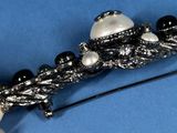a close up of a brooch with pearls on it