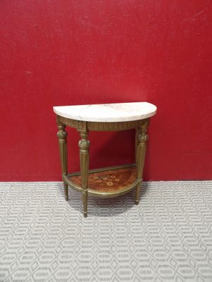 a small table with a marble top in front of a red wall