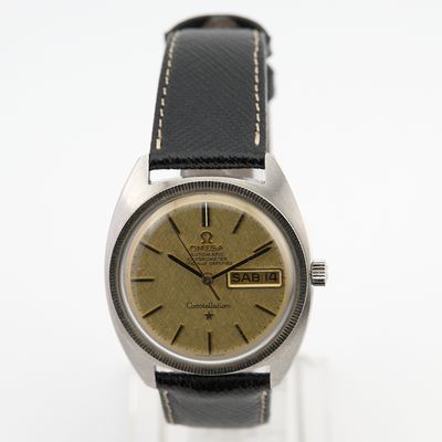 une photo d'une montre avec un cadran doré et un bracelet en cuir noir