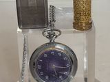 une horloge et un briquet posés sur une table où se trouve une bougie