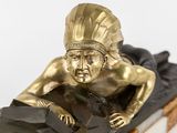 statue of a man laying on a rock with a feather on his head