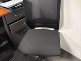 a black office chair sitting in front of a computer desk