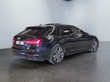 the back end of a black car parked in a garage