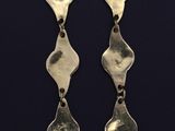 a pair of silver earrings on a black background