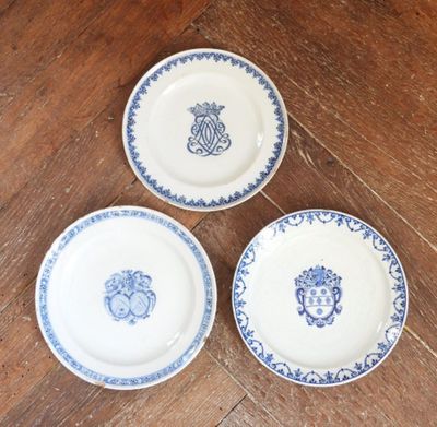 trois assiettes ornées de motifs bleus et blancs, posées sur une table en bois