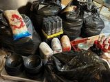 many bags of food sitting on the floor next to a stove