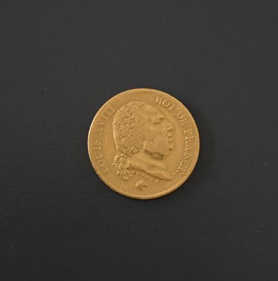 a close up of a gold coin on a black surface