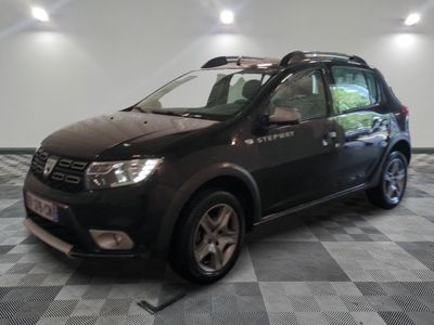 une photo d'une Dacia noire garée dans un garage