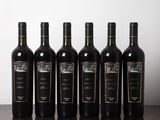 six bouteilles de vin sont alignées sur une table en bois