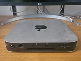 an apple computer sitting on top of a wooden desk next to a monitor