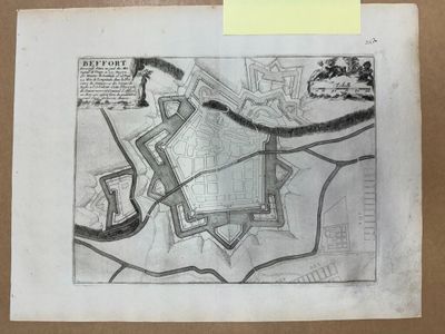 une vieille carte d'une ville dessinée sur un bout de papier, sur laquelle est collé un post-it