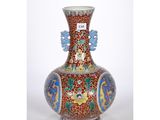 un vase rouge orné de motifs bleus et jaunes