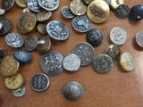 many different types of buttons on a wooden table