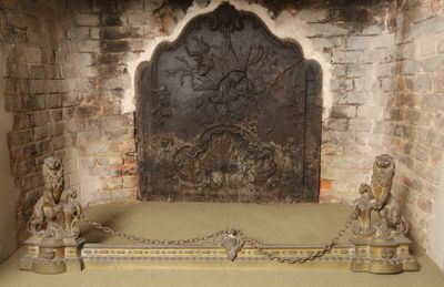 a stone fireplace with statues on it in a room