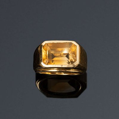 une bague en or sertie d'une citrine sur un fond noir
