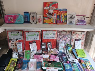 a lot of school supplies on a shelf next to a window