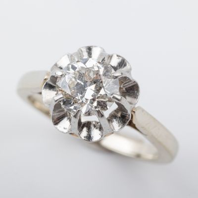 a close up of a diamond ring on a white surface