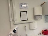 a bathroom with a sink, mirror, toilet, and other items on the wall