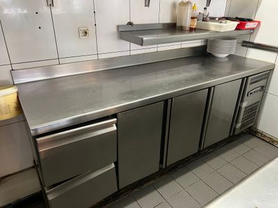 plan de travail en acier inoxydable dans une cuisine professionnelle équipée d'un lave-vaisselle