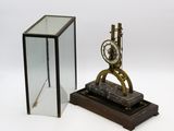 une image représentant une horloge posée sur un socle en bois, à côté d'une vitrine