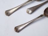three spoons and two spoons sitting on a table