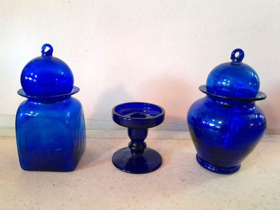 Lot de deux flacons en verre bleu ( H. 18 cm) et un petit bougeoirs su