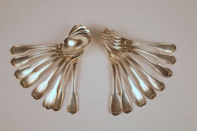 deux cuillères en argent et des cuillères posées sur une table