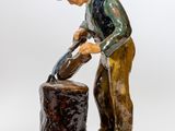 figurine représentant un homme versant de l'eau d'un seau, sur fond blanc