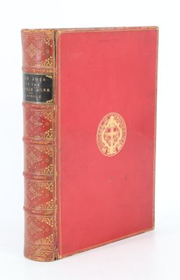 un vieux livre à la couverture rouge posé sur une surface blanche