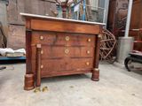a wooden dresser with a marble top in the middle of a room