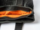 a black purse with an orange lining inside of it