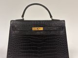 a black crocodile skin handbag with gold hardware