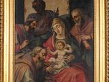 une peinture à l'huile représentant un homme tenant un bébé dans ses bras devant un groupe de personnes