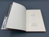 un livre ouvert posé sur une table, à côté d'un sac