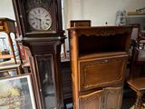 une horloge de parquet posée à côté d'un buffet dans une pièce