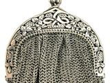 a close up of a silver purse with a chain around it