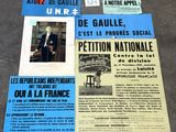 plusieurs affiches posées à même le sol d'un immeuble, sur lesquelles figurent des photos de personnes