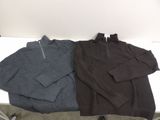 three men ' s sweaters are lined up on a white table