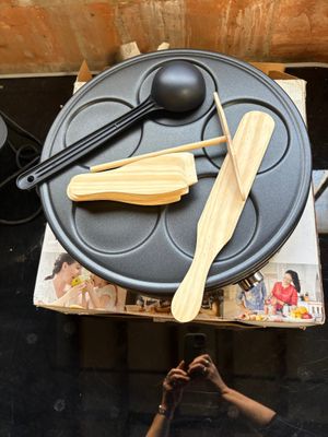 someone is taking a picture of a table with a pan, spoon, and spatula on it