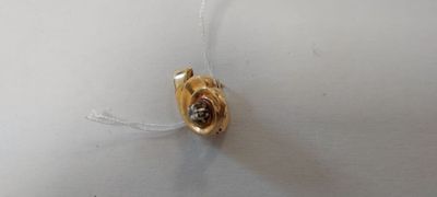 un petit objet en or suspendu à un fil accroché au mur
