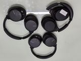 four sony headphones sitting on top of each other on a table