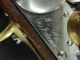 a close up of a brass plated gun with a wooden handle