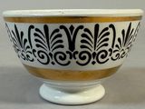 a black and white bowl with gold trim on it