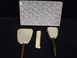 two hair brushes and a comb on a black surface