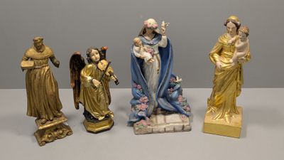 quatre figurines représentant Jésus, Marie et d'autres personnages religieux, posées sur une table