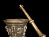 an old mortar and a wooden pestula on a black background