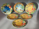 six decorative plates with different designs on them sitting on a table