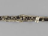 a close up of a clarinet on a white surface